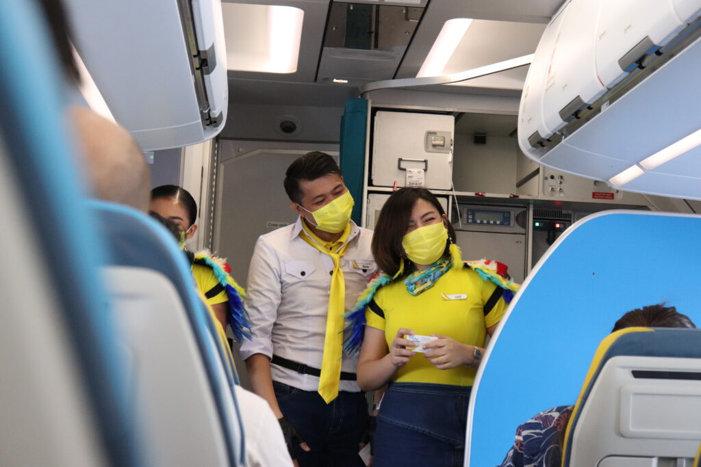 Flight attendants wear the bright colors of the Adarna
